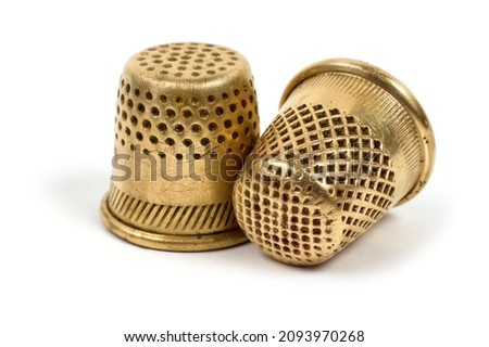 Antique copper thimbles for sewing. Close-up items on a white background. Royalty-Free Stock Photo #2093970268