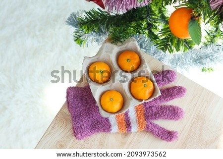 Fresh Tangerines in egg box with on wooden table with christmas tree,christmas concept.