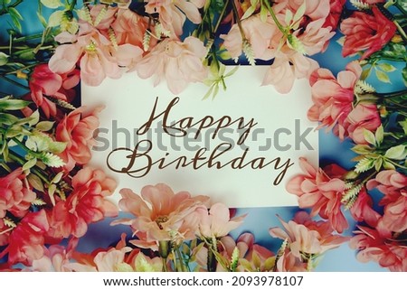 Happy Birthdaytext with flower frame on blue background