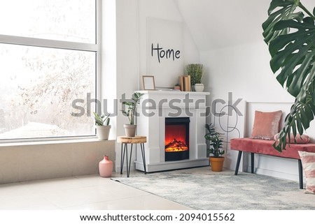 Stylish interior of living room with fireplace near window