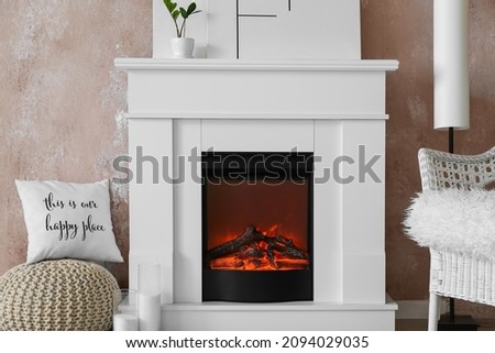 Modern fireplace near color wall