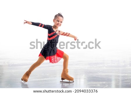 Little skater posing in red and black dress on ice isolated on white background