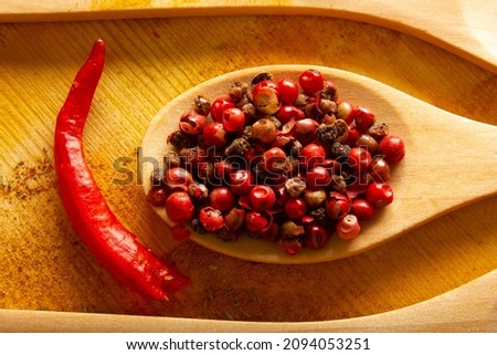 red peppercorns in wooden spoon