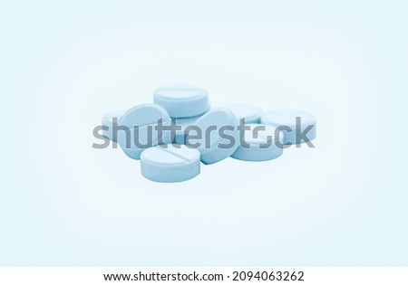 Medical pills on a light background in blue shades.
