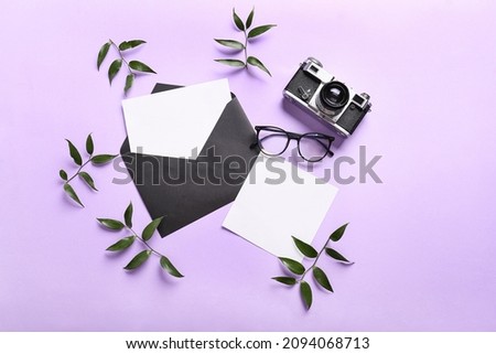 Composition with envelope, blank cards, eyeglasses and photo camera on color background