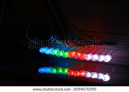 Glowing Light emitting diodes with reflections on the glass, LED bulbs displaying colorful lights Royalty-Free Stock Photo #2094070390