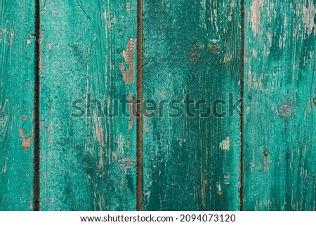 texture of a wooden fence.  fence painted green.  peeling paint on an old fence.  old wood texture.  photo can be used as a photophone, as a texture