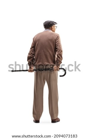 Full length rear view shot of an elderly man standing and holding a cane behind his back isolated on white background