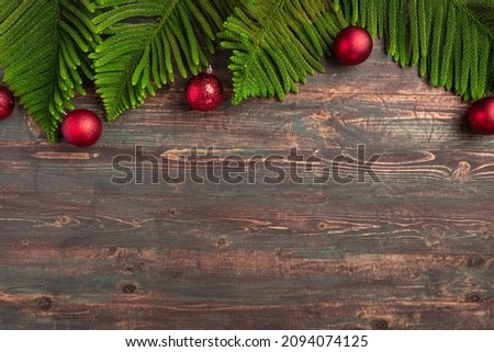 Christmas pine leaf with bauble decoration on wooden table