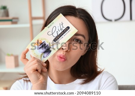 Young Asian woman with gift certificate for massage at home