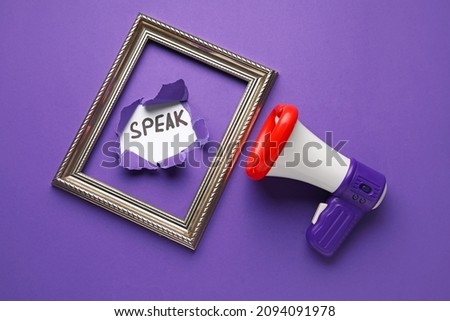 Toy megaphone with frame and word SPEAK visible through torn color paper