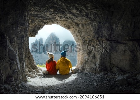
Couple of mountaineers observe the views of Tre Cime di Lavadero from inside a cave in the Italian Alps Royalty-Free Stock Photo #2094106651
