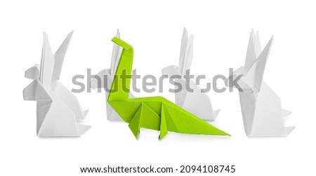 Origami dinosaur and rabbits on white background. Concept of uniqueness
