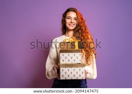 Christmas young woman wear white sweater holds many white gold gifts boxes on purple studio background. Christmas concept. Sales 
