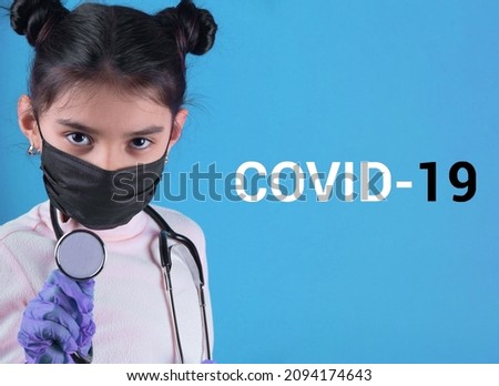 Little funny girl with a medical black mask.Coronavirus blue background. Funny expression. Covid-19. panorama background. Stop covid-19