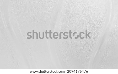 macro shot of cool water drops on white plastic bottle texture