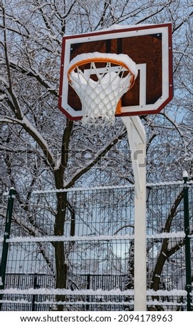 basketball hoop on the court covered with snow after a snowfall. High quality photo