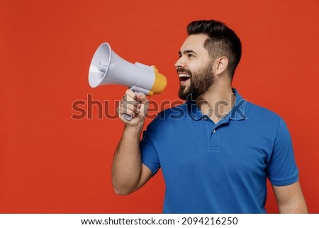 Young smiling happy caucasian man 20s wear basic blue t-shirt hold scream in megaphone announces discounts sale Hurry up isolated on plain orange background studio portrait. People lifestyle concept Royalty-Free Stock Photo #2094216250