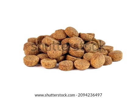 Brown crunchy organic kibble pieces for dog feed heap isolated on white background. Healthy dry pet food Royalty-Free Stock Photo #2094236497