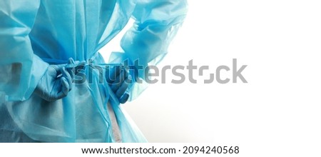 Rear view of a medical worker wearing a  protective medical suit to protect against coronavirus. Copy space in banner size. Royalty-Free Stock Photo #2094240568