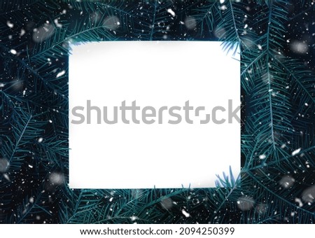 Creative layout made of winter evergreen tree branches with paper note or greeting card. Nature Christmas concept. Flat lay.