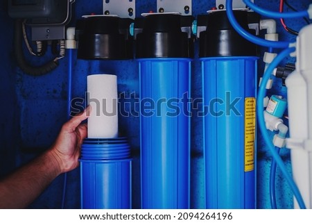 Water filter system or osmosis, Replacing the water filter, water-purification. Commercial use. Selective focus.	                     Royalty-Free Stock Photo #2094264196