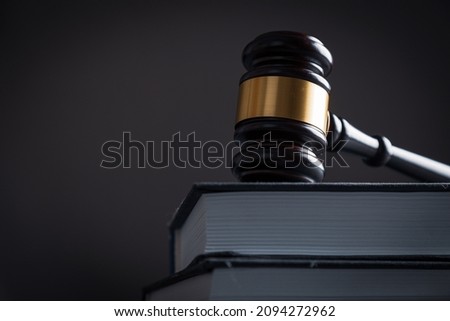 Judge's gavel on a homogeneous background with books. Justice and injustice, law