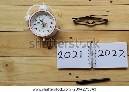 Text 2021-2022 on wooden table background. Welcoming new year. Selective focus.