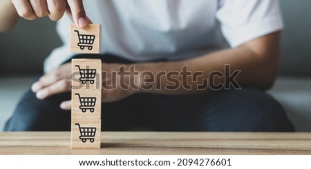 Close up image of business man hand flipping sale volume increase make business grow with icon graph and shopping cart symbol.