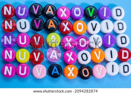 Nuvaxovid logo. Letters with the name of the antivirus for children with a slope and change effect. High angle photo, soft focus.