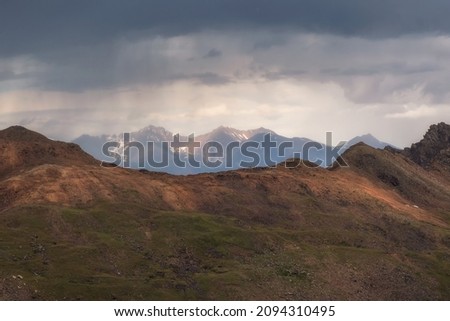 Landscape on the rainy high plateau. Dramatic sky on mountain peaks. Mystical background with dramatic mountains.