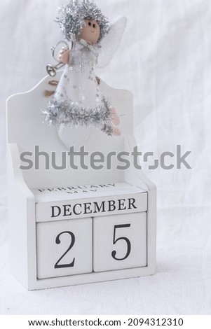 White Christmas angel and the date December 25th, date calendar on white background.  Advent calendar, Christmas background, Copy space