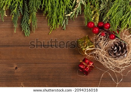 Christmas gift, christmas concept with christmas tree branches and pinecone on wooden background.	
