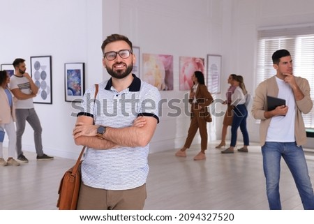 Happy young man at exhibition in art gallery