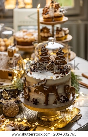 Christmas cake holiday dessert decorated with gingerbread cookies in different shapes