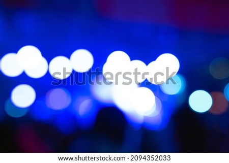 Concert background photo. Defocused spotlights on stage. Blurry concert background with silhouette of people.