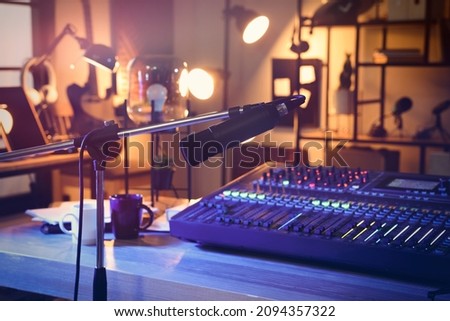 Microphone near table with professional mixing console in radio studio