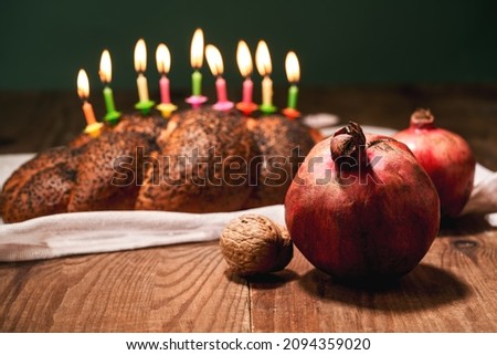 Candles, pomegranate and homemade challah on Shabbat before Hanukkah