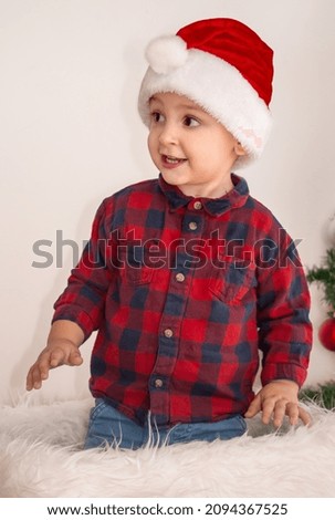 Child playing near Christmas tree in living room as a Christmas gift. Cute little boy pops-up from Santa Claus present box - Christmas lifestyle
