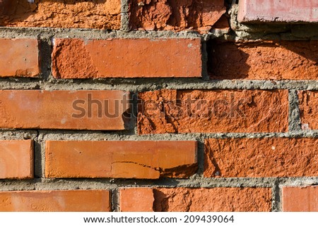 Background, a wall made of red bricks, partially crumbled. Old building