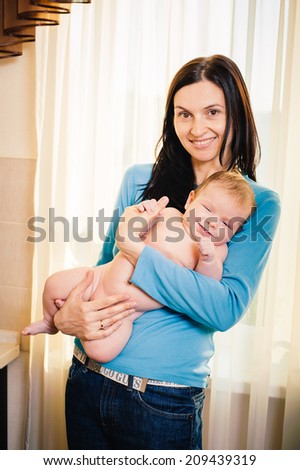Young mother and her adorable baby boy. Beautiful mother holding baby boy, mom carry cute child adorable small son, happy family picture, mom and kid indoor brunette Arabic models, happiness concept