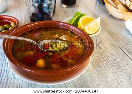 Typical Majorcan dish called Arroz Brut. Served with green pepper stripes and lemon wedges.  Some red wine and olives also accompanying the food. Royalty-Free Stock Photo #2094400147