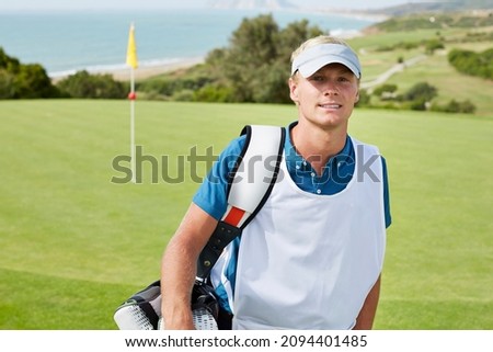 Caddy smiling on golf course Royalty-Free Stock Photo #2094401485