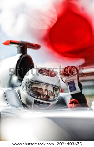 Racer cheering in car on track Royalty-Free Stock Photo #2094403675