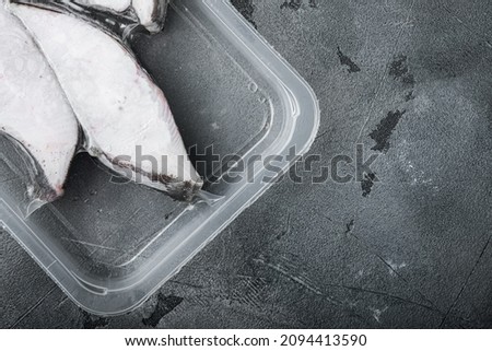 Frozen halibut pack  set, on gray stone table background, top view flat lay, with copy space for text