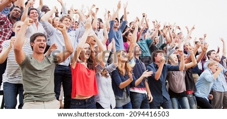 Cheering fans in crowd at sporting event Royalty-Free Stock Photo #2094416503