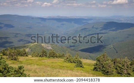 meadow on a mountain ridge and wooded mountain valleys