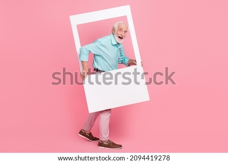 Full size profile side photo of energetic middle age man hold photograph border step away isolated pastel color background
