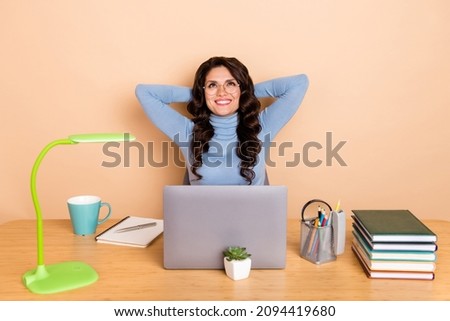 Photo of smart thoughtful lady dressed pullover glasses arms behind head empty space isolated beige color background