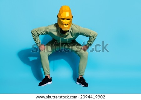 Photo of serious cool man wear primate mask dancing stomping legs isolated blue color background